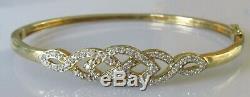 Secondhand 9ct yellow gold multi diamond crossover hinged bangle/bracelet (9.8g)