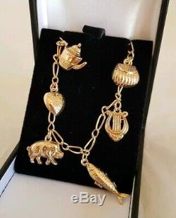 Vintage 9ct Yellow gold bracelet. Suspended from which are Eight 9ct charms