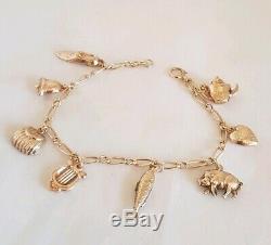 Vintage 9ct Yellow gold bracelet. Suspended from which are Eight 9ct charms