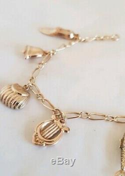 Vintage 9ct Yellow gold bracelet. Suspended from which are Eight 9ct charms