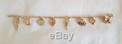 Vintage 9ct Yellow gold bracelet. Suspended from which are Eight 9ct charms