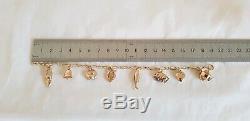 Vintage 9ct Yellow gold bracelet. Suspended from which are Eight 9ct charms